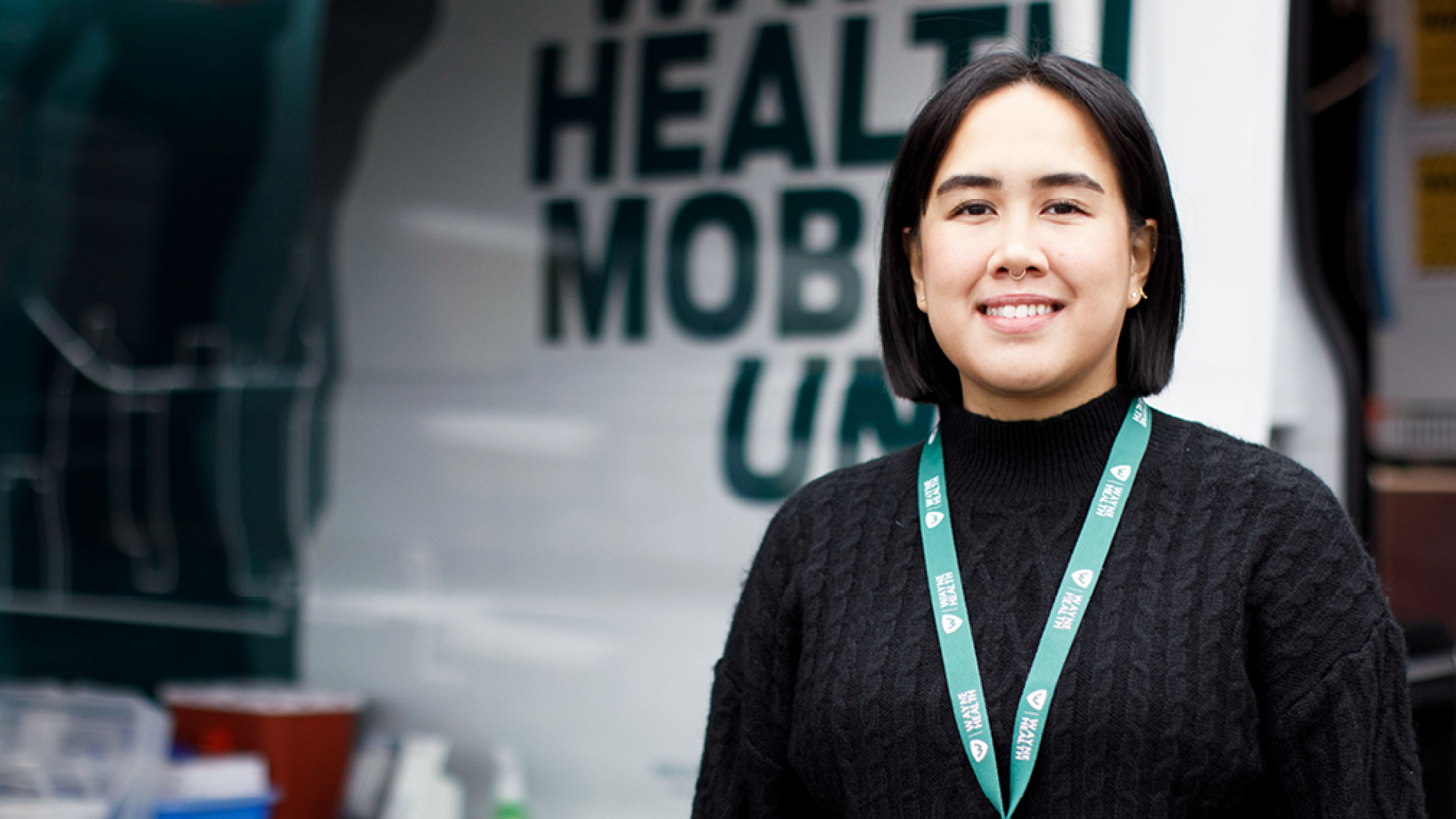 A woman next to a mobile health unit