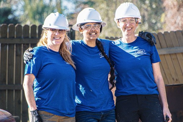 A woman taking a box of donations out of a trunk